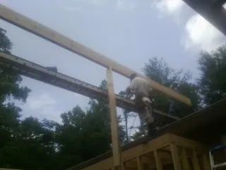 Carpenter setting a ridge beam over a new addition frame — Ice Dam Removal by Roofing Brothers in Dexter City