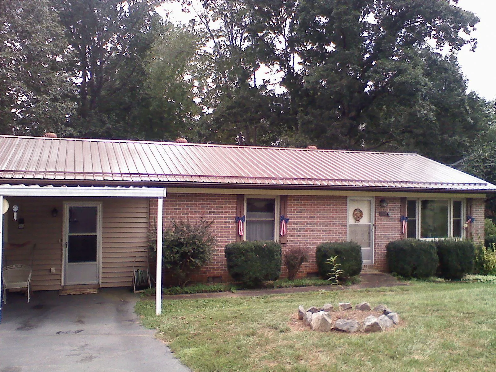 Bronze metal roof and carport on a brick ranch home — Roof Repair work by our crew in Dexter City