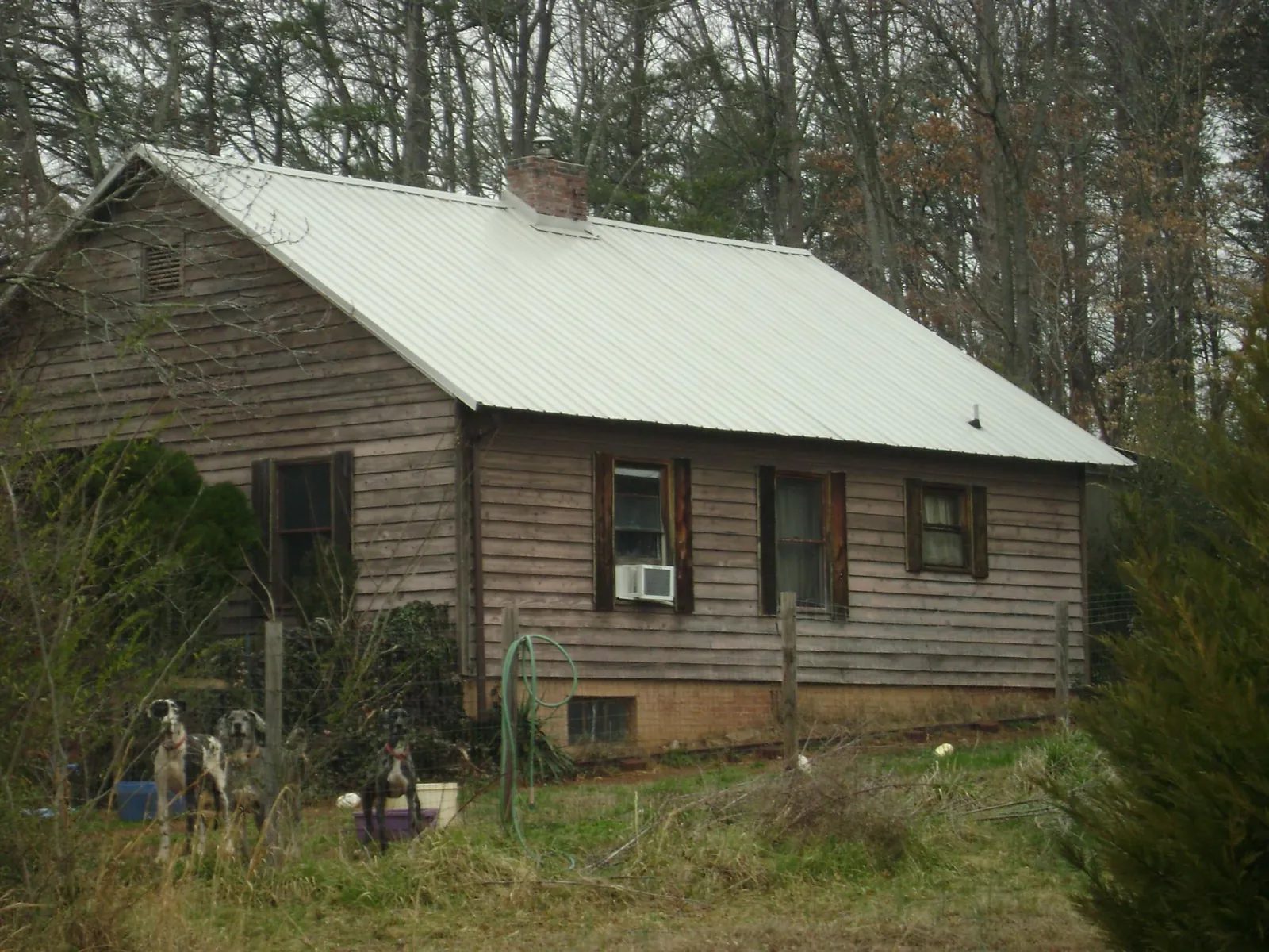 White metal roof on an old wood sided farmhouse, from a Metal Roof Installation job in Dexter City